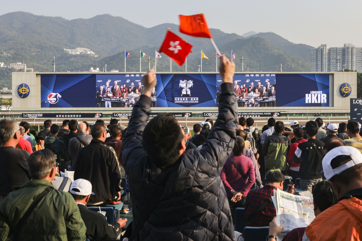 A racing fan waves the flags of Hong Kong and China during the Hong Kong International Races. Photo: Sam Tsang