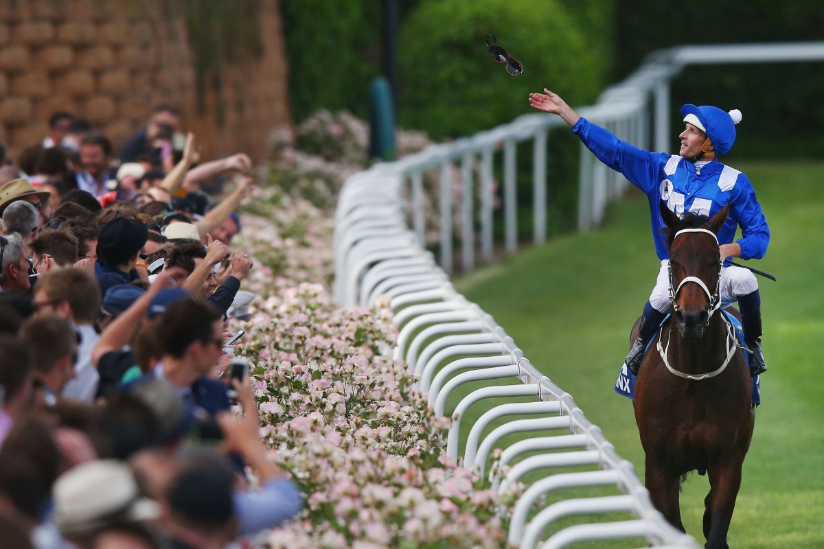 Hugh Bowman throws his goggles into the crowd after winning the 2015 Cox Plate with Winx. Photo: Michael Dodge/Getty Images