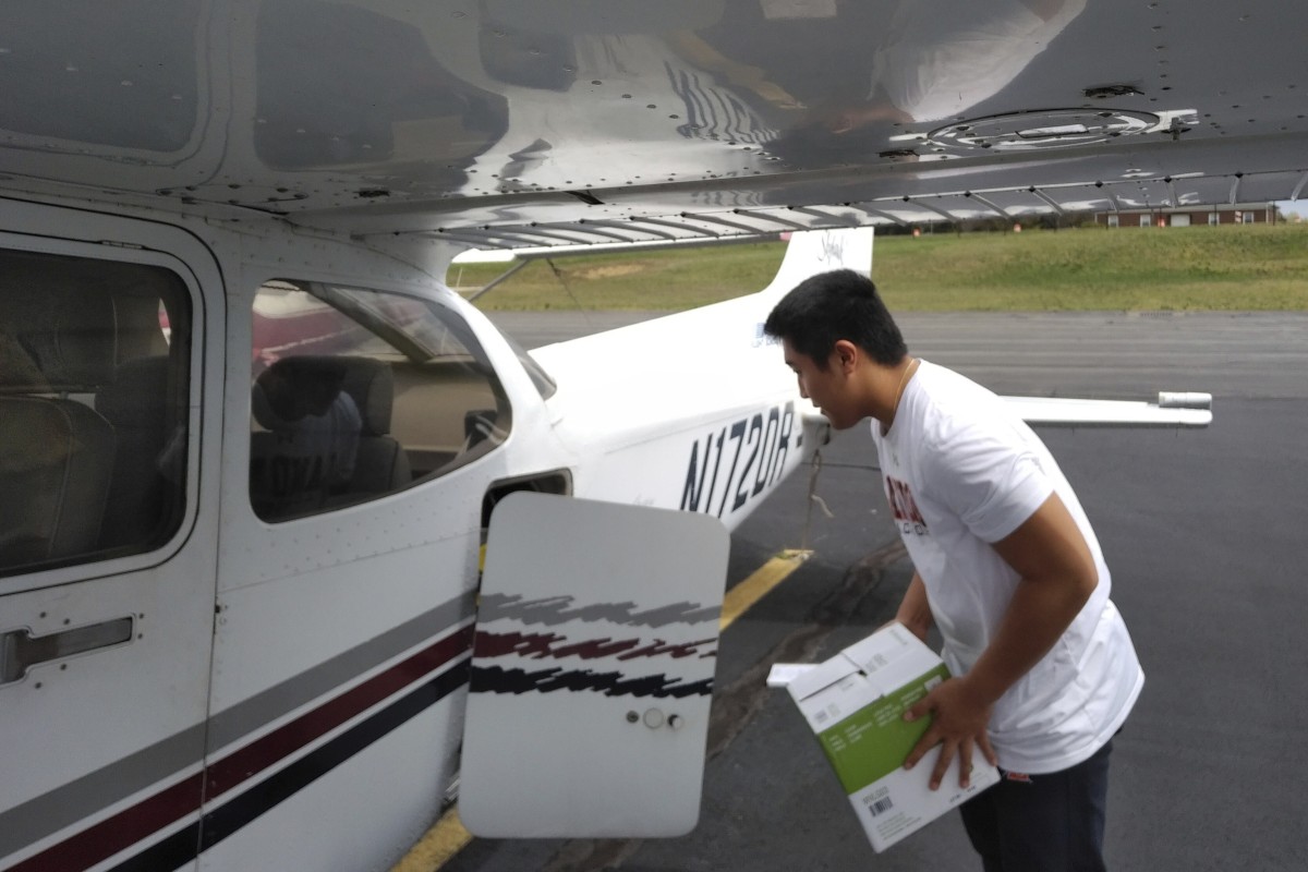 In this March 27, 2020 photo provided by Thomas Kim, TJ Kim, 16, loads medical supplies into a plane in Leesburg, Va., before flying to a hospital in Luray. Kim began delivering donated medical supplies to rural hospitals in need after realizing his flight training could be put to good use during the coronavirus pandemic. (Thomas Kim via AP)