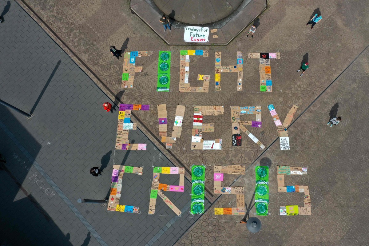An aerial view shows demonstrators of the Fridays for Future environmental movement practicing social distancing as they stand next to placards arranged to form the words 'fight every crisis' in front of the city hall in Essen, western Germany, on April 24, 2020. Photo: AFP
