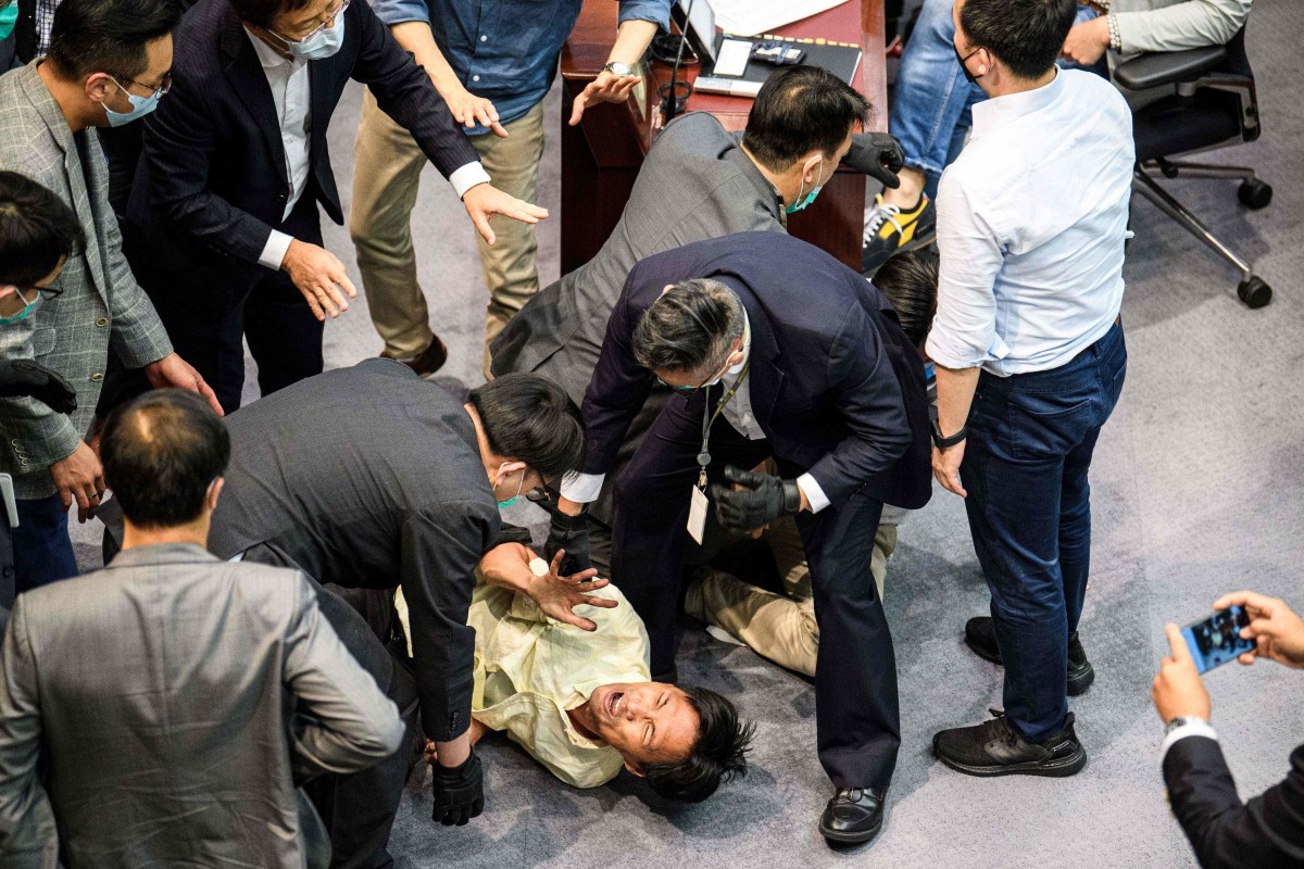 Pro-democracy lawmaker Eddie Chu (bottom C) is surrounded by security as he and other pro-democracy lawmakers scuffle with pro-Beijing lawmakers and Legco security.