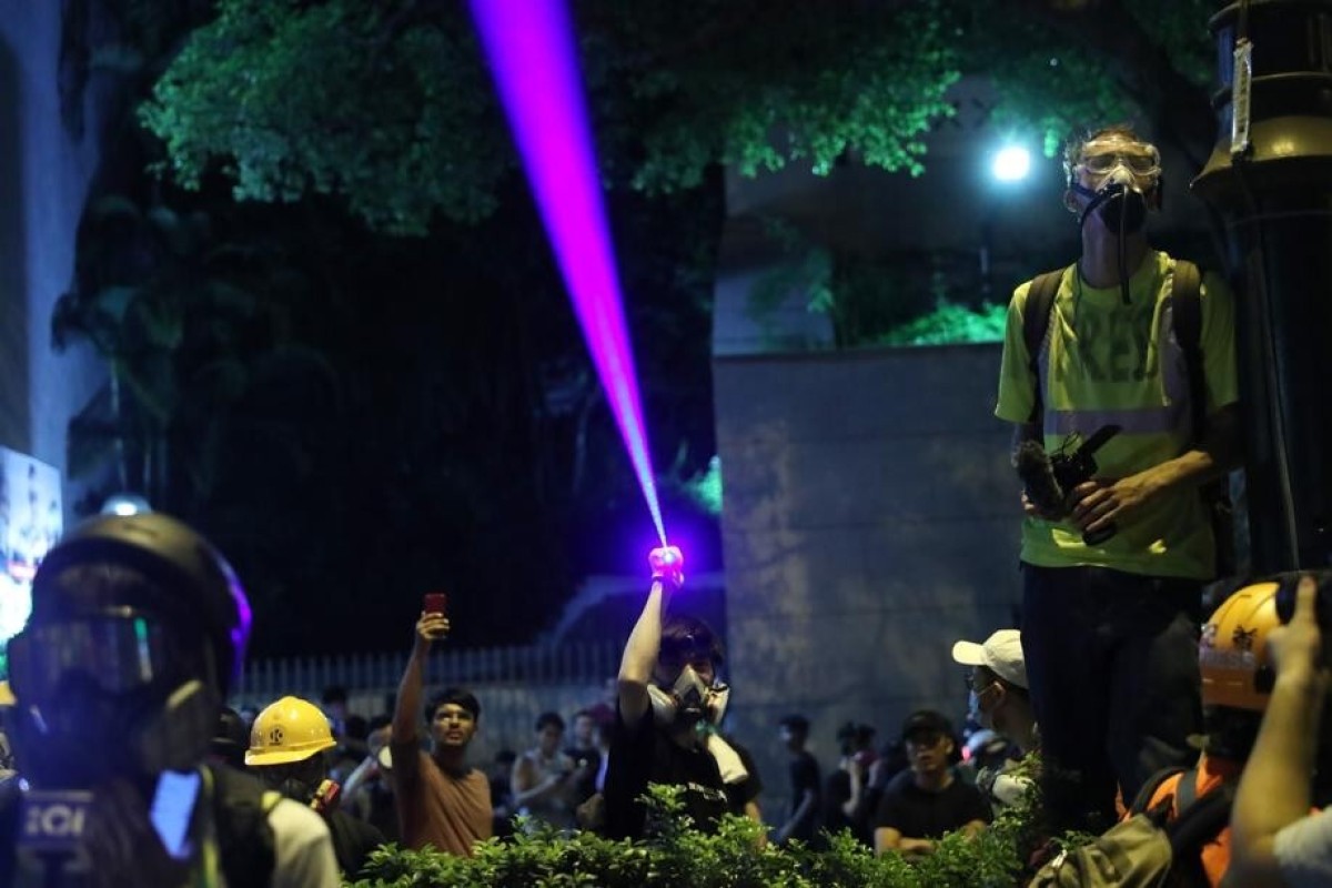 An anti-government protester shines a laser pointer at police in Tsim Sha Tsui in August.