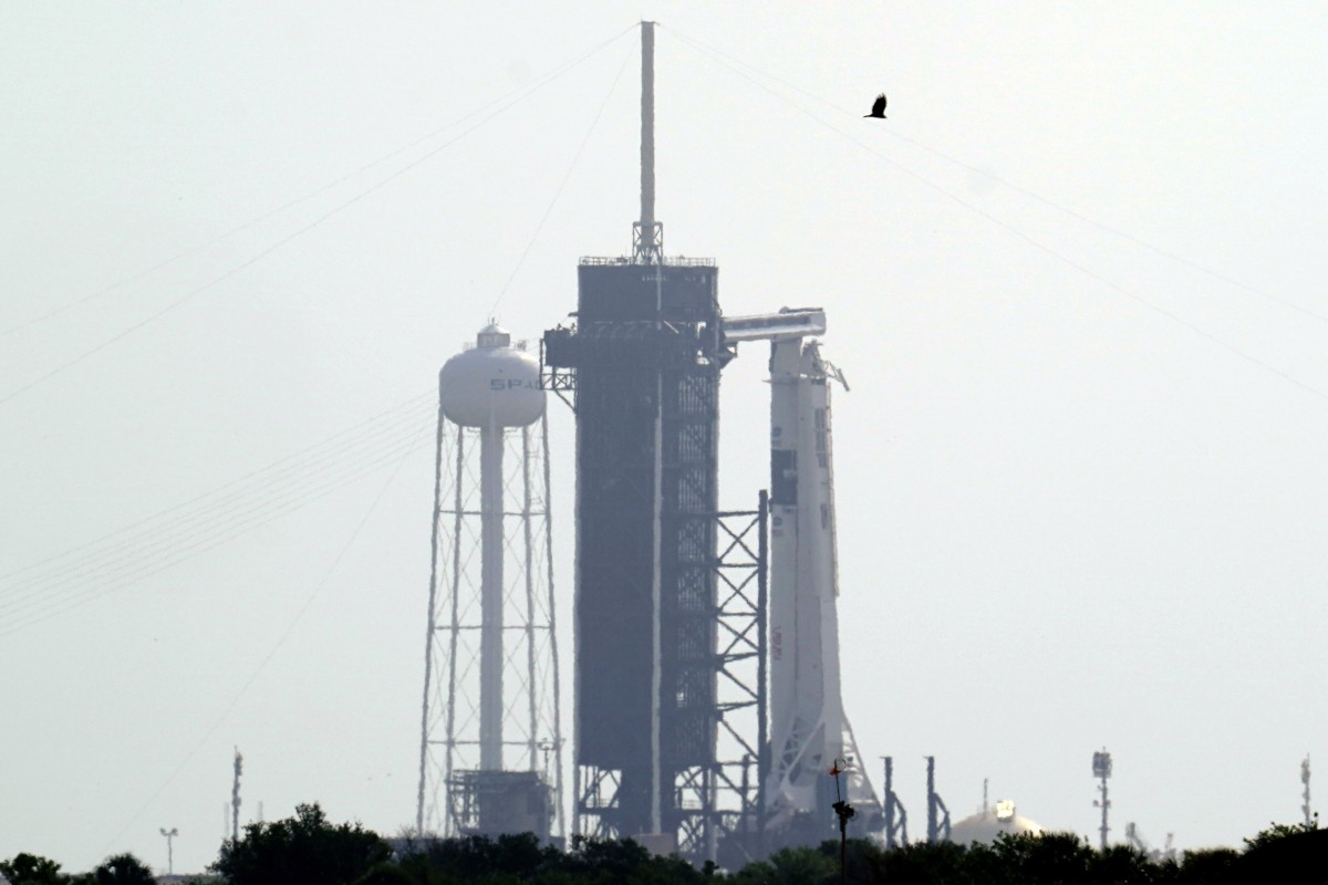 The SpaceX Falcon 9, with the Crew Dragon spacecraft on top of the rocket, sits on Launch Pad 39-A at Kennedy Space Center in Cape Canaveral after the planned launch was scrubbed due to bad weather.