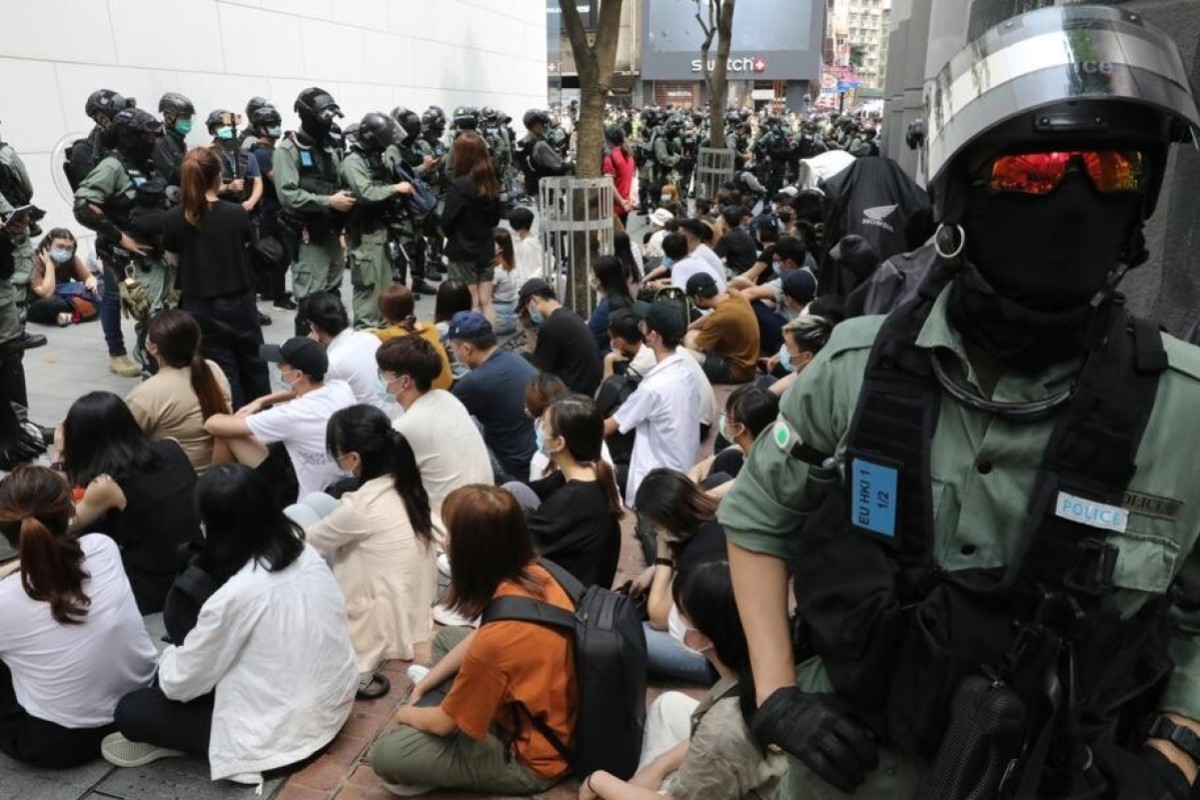 Police detain a group of anti-government protesters outside Hysan Place in Causeway Bay.