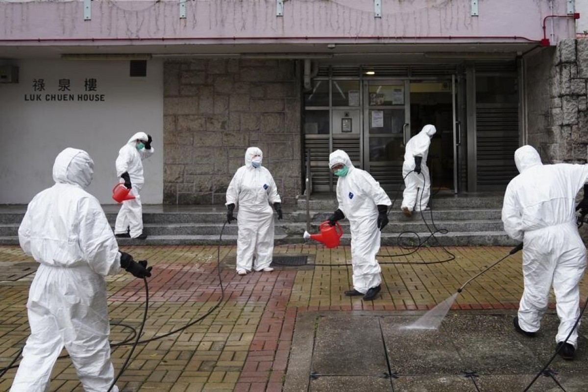 Workers in protective gear disinfect Luk Chuen House at Lek Yuen Estate in Sha Tin.