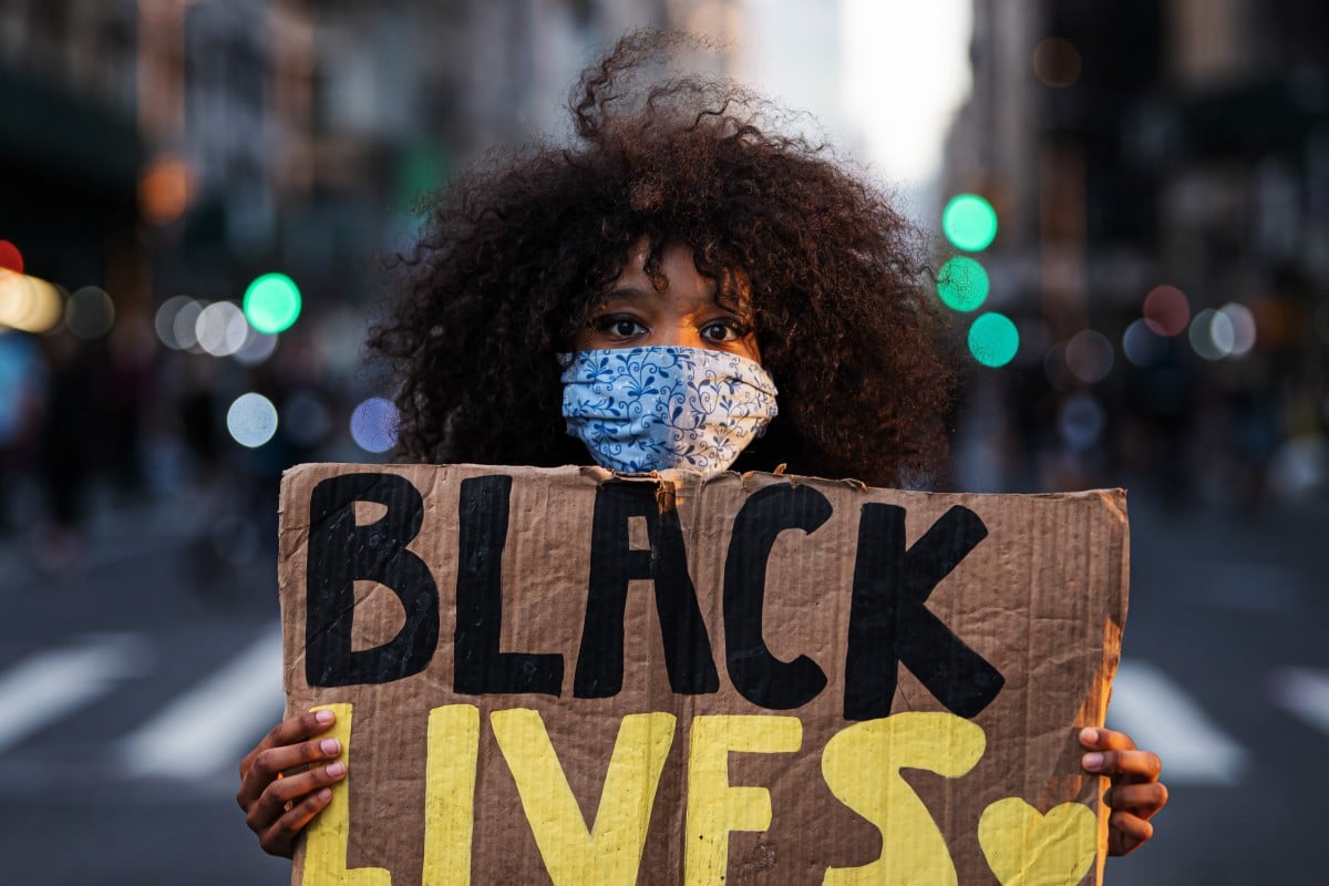 A woman poses with a Black Lives Matter sign during a protest following the violent death of the African-American George Floyd by a white policeman in Minneapolis. Photo: Joel Marklund/Bildbyran via ZUMA Press/DPA