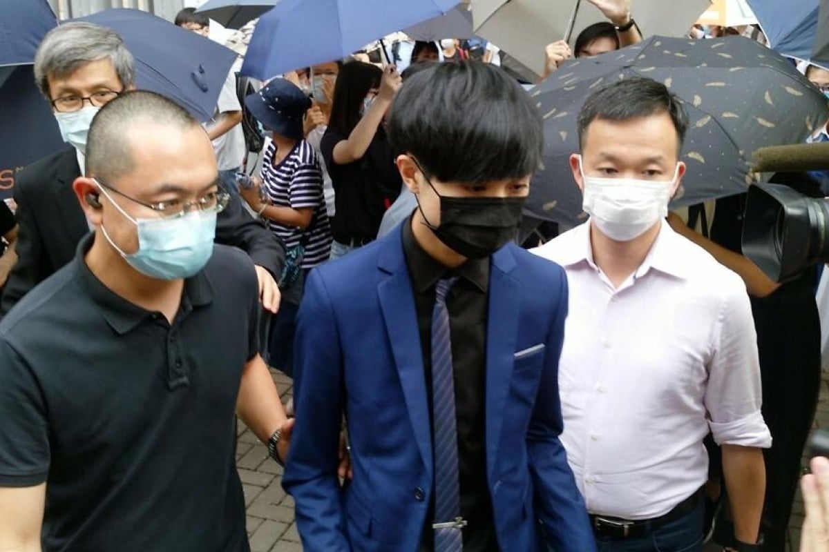 Chow Pak-kwan (centre) walks out of West Kowloon Court after being granted bail on Tuesday.