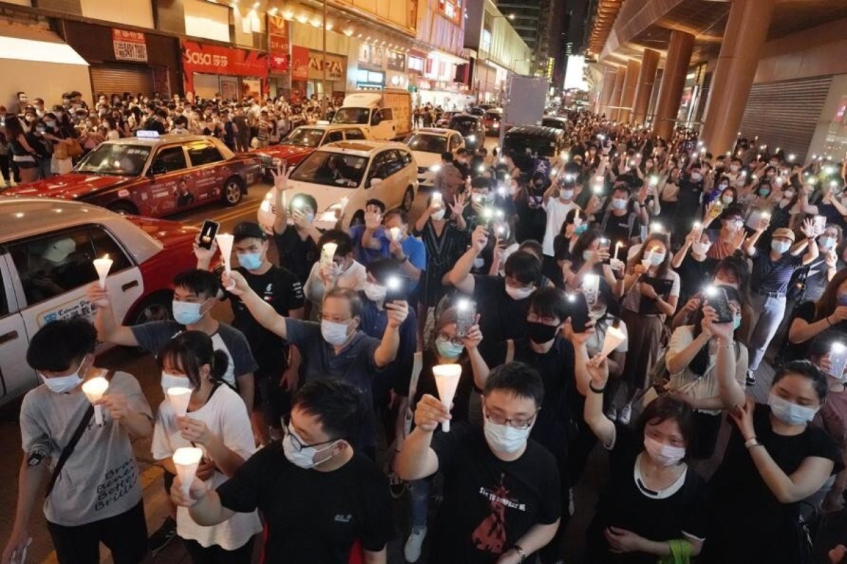Hongkongers hold up candles for the vigil, along with five outstretched fingers, representing the five demands of the pro-democracy movement.
