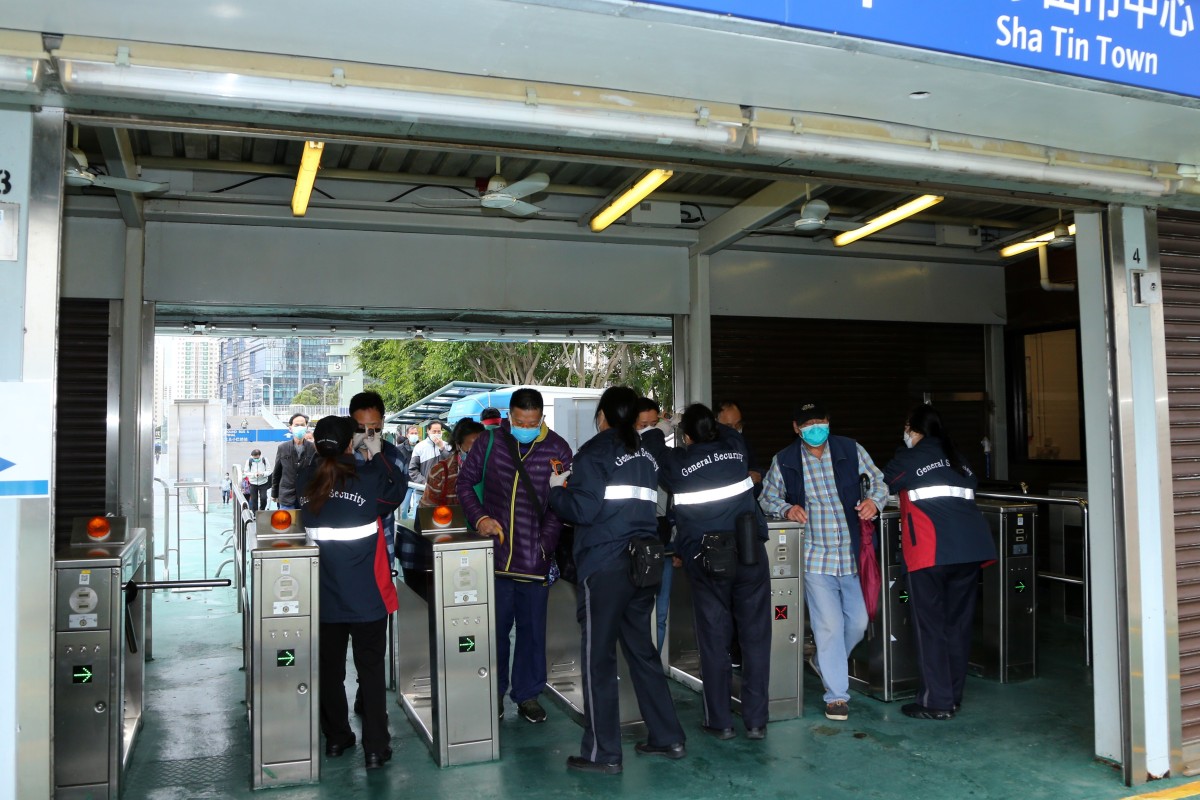 Security guards temperature screen customers at the entrance to Sha Tin racecourse. Photo: Kenneth Chan