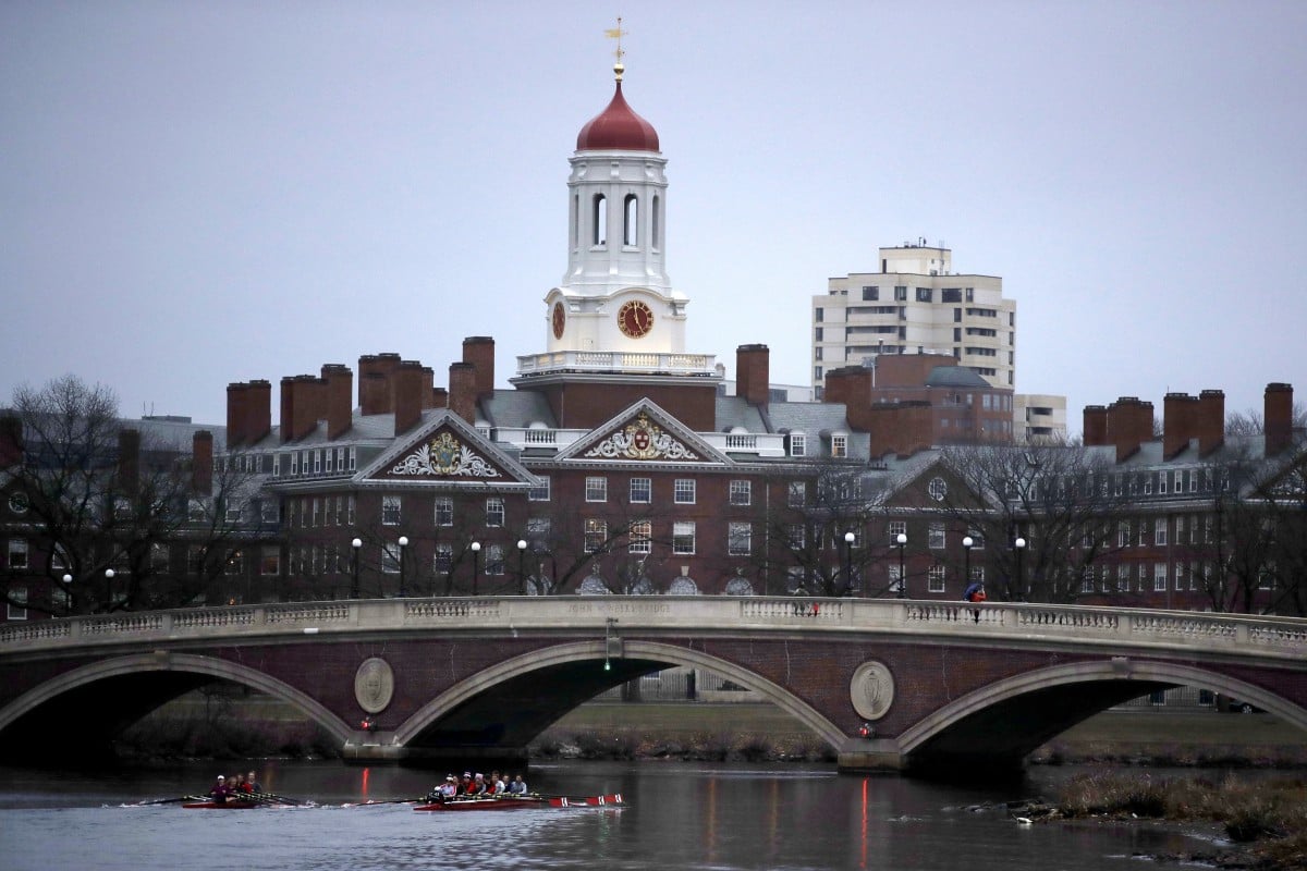 FILE - In this March 7, 2017 file photo, rowers paddle down the Charles River past the campus of Harvard University in Cambridge, Mass. An annual survey finds that most U.S. universities made money on their financial investments last year, but their returns were tempered by a global economic slowdown fueled by America's trade war with China. Harvard University remained the wealthiest school in the U.S., with an endowment valued at nearly $40 billion. (AP Photo/Charles Krupa, File)
