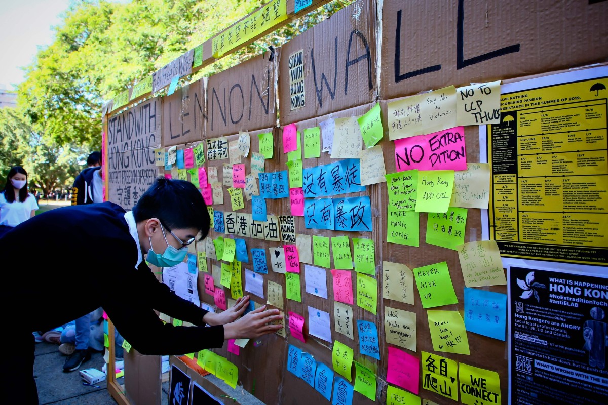 This photo taken on August 9, 2019 shows a supporter of the Hong Kong pro-democracy protests posting a note on a makeshift "Lennon Wall" at the University of Queensland in Brisbane. Photo: AFP