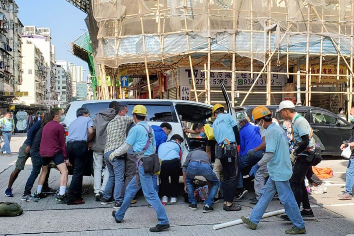 A groups of passers-by worked together to free an elderly woman trapped under a car. Photo: Facebook