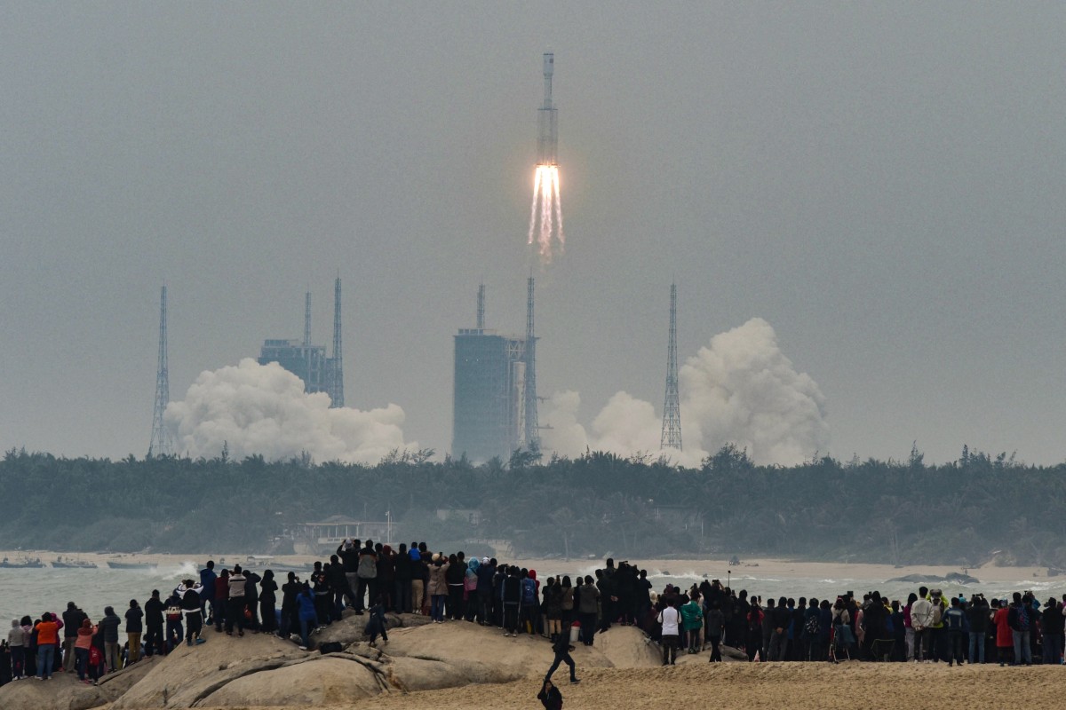 People watch China's new medium-size rocket, Long March 8, lifting from Wenchang Space Launch Center. Debris from a Chinese rocket threatens to fall to Earth in the next few days after it was used to launch the core module of China's new space station.
