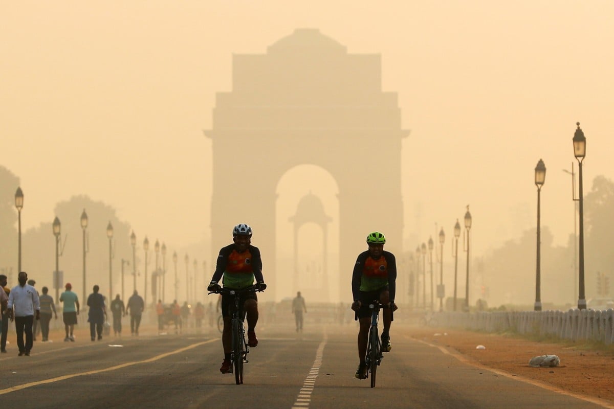 Men ride their bicycles in front of the India Gate, shrouded in smog, in New Delhi, India. Photo: REUTERS