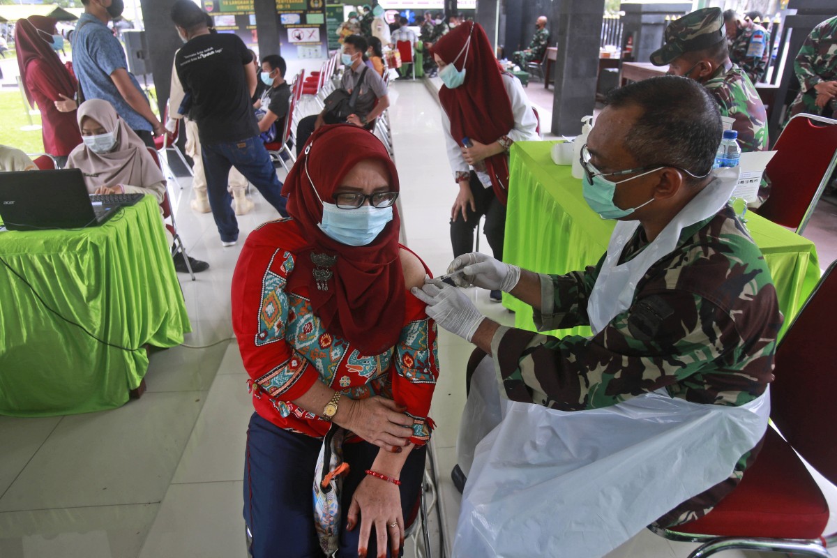 A woman receives a shot of the Sinovac vaccine during a mass vaccination drive in Indonesia. The world's fourth most populous country has seen Covid-19 infections surge in recent weeks, a climb that has been blamed on travel during last month's Eid al-Fitr holiday, as well as the arrival of new virus variants, such as the delta version first found in India. Photo: AP