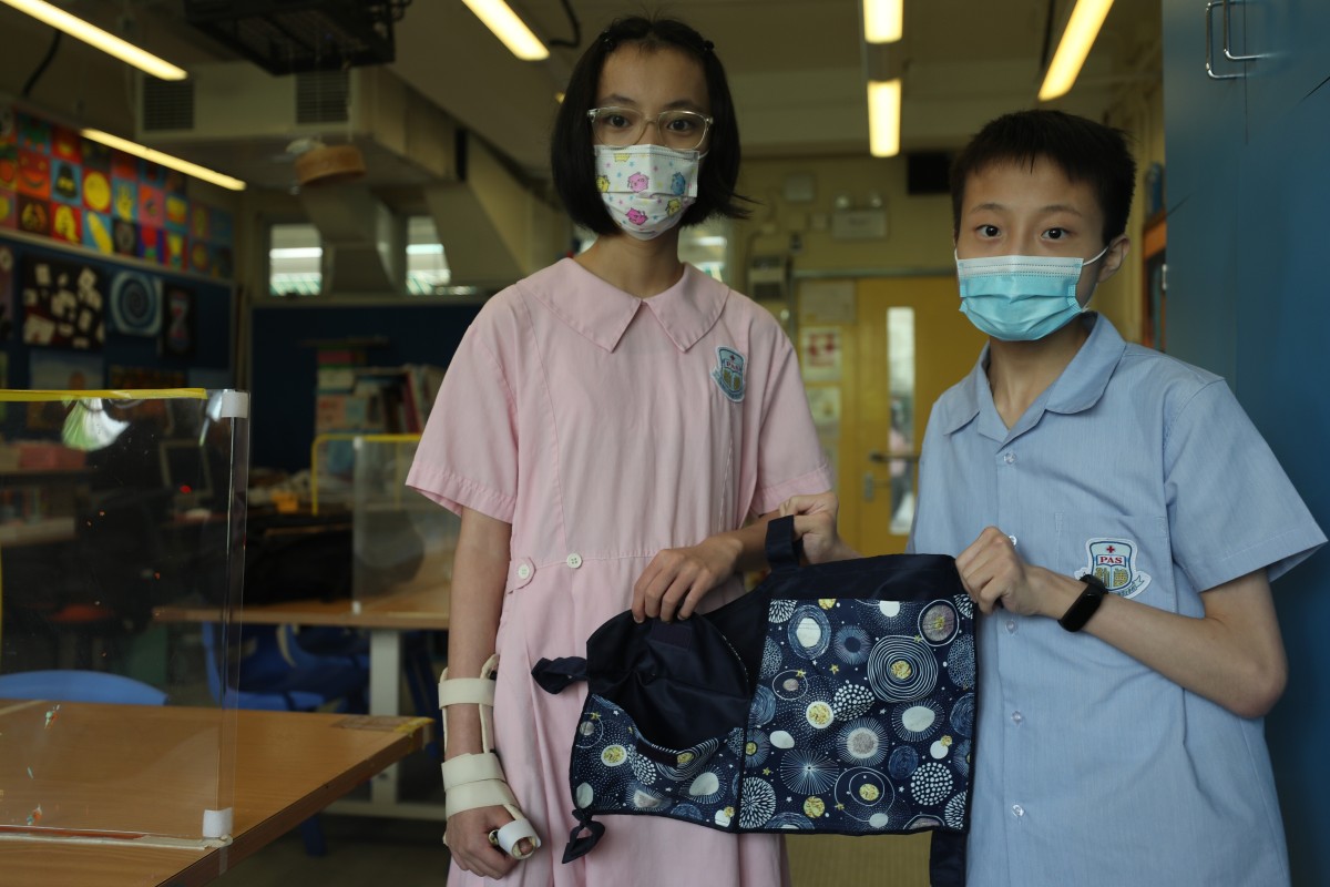Spirit of Hong Kong nominees and Hong Kong Red Cross Princess Alexandra School Form 3 students Fu Lee-Lee (left) and Yeung Chin-hang show off a pouch they designed to make life easier for people with walking aids. Photo: SCMP / Xiaomei Chen