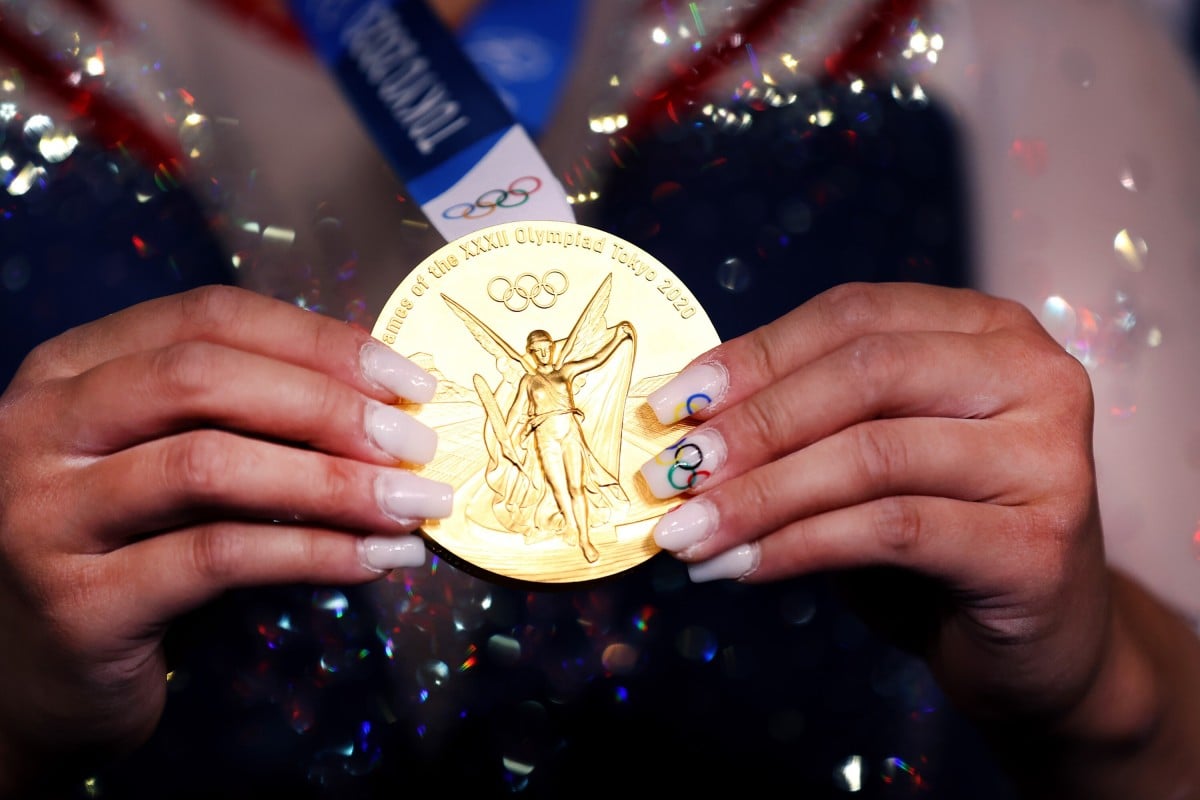 After winning the women's all-around final, US Olympic gymnast Sunisa Lee holds her gold medal, as she shows off her acrylic nails. Photo: Getty Images / TNS