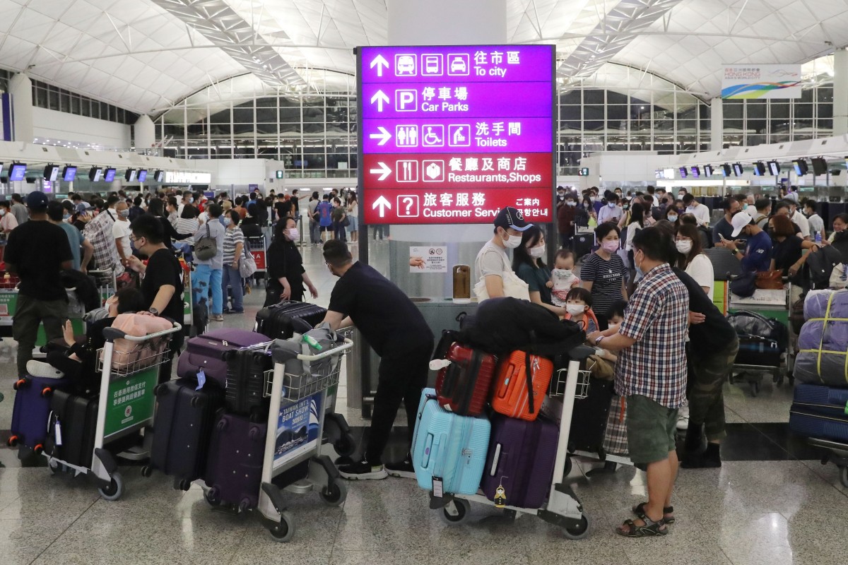 Passengers wait at check-in counters at Hong Kong International Airport in June 2021. Around 90,000 people have left the city in the last year. Photo: SCMP/Edmond So