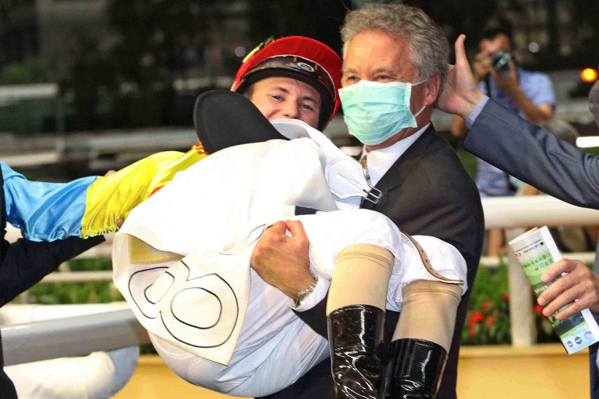 Trainer David Ferraris lifts up son Luke after the 19-year-old rode his first Hong Kong winner aboard Go Ballistic. Photos: Kenneth Chan