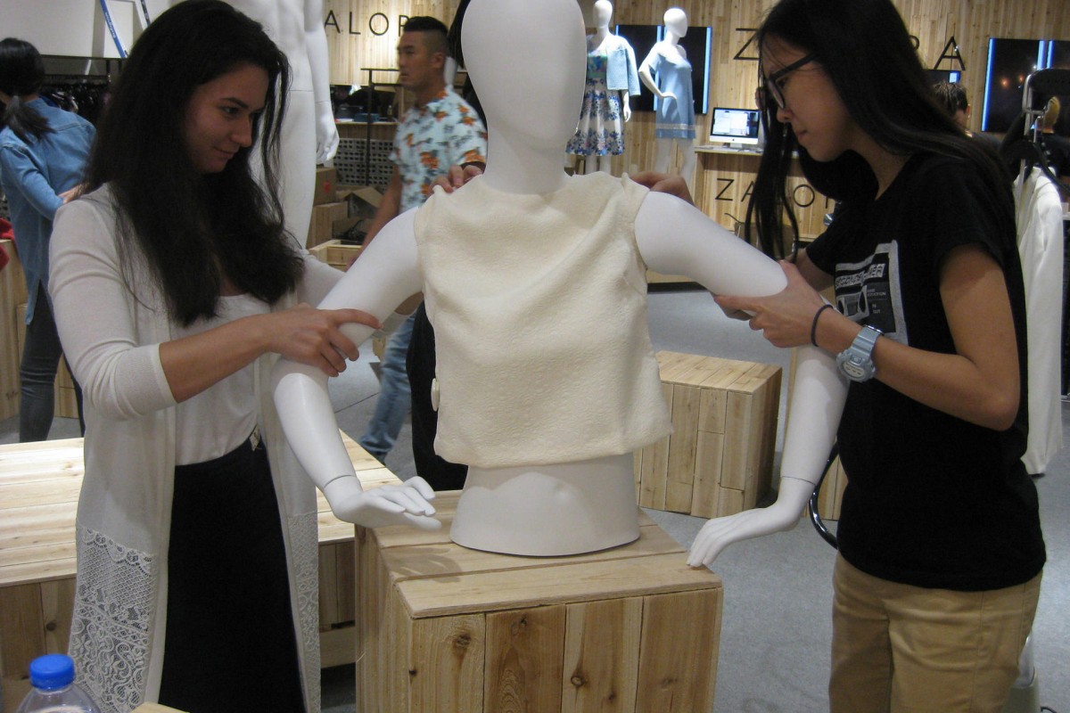 Emily (left) and Christy dress a mannequin.