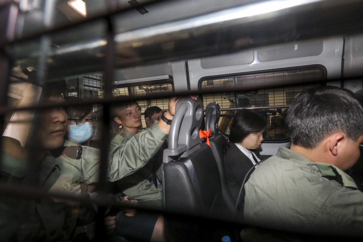 Ng Lung-ping, seen in a mask on the left, and Choi Yuk-wan (second from right) on their way to Eastern Court where they were accused of wearing masks during a public assembly.