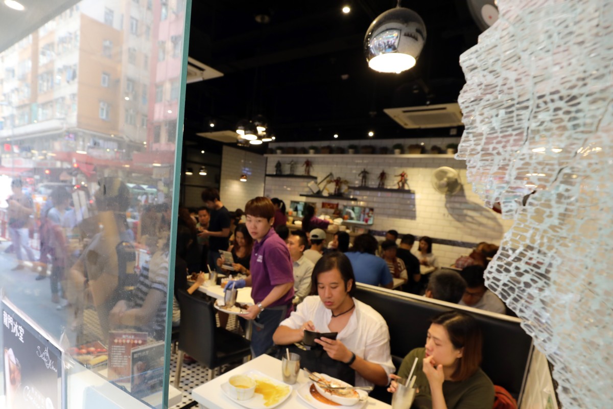 Lung Mun Cafe customers come out in force with the signs of the early morning attack still highly visible.