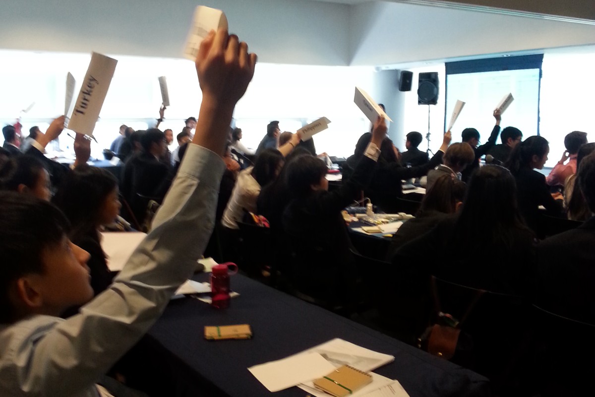 Student delegates at MUN voting on motions.