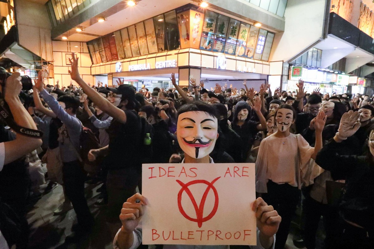Anti-government protesters with Guy Fawkes masks in Tsim Sha Tsui on Tuesday.