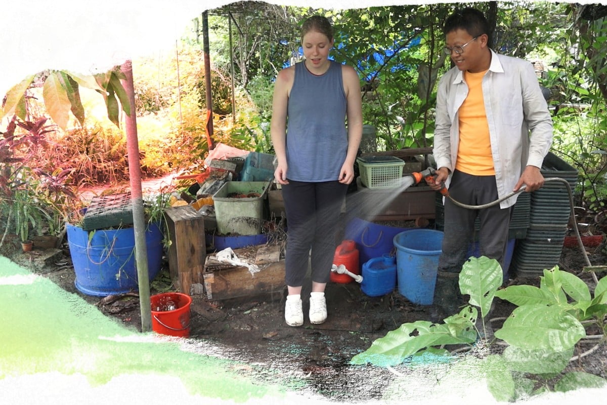 Choi Wing-lun (right) hands Charlotte Ames-Ettridge a hose so she can water the plants.