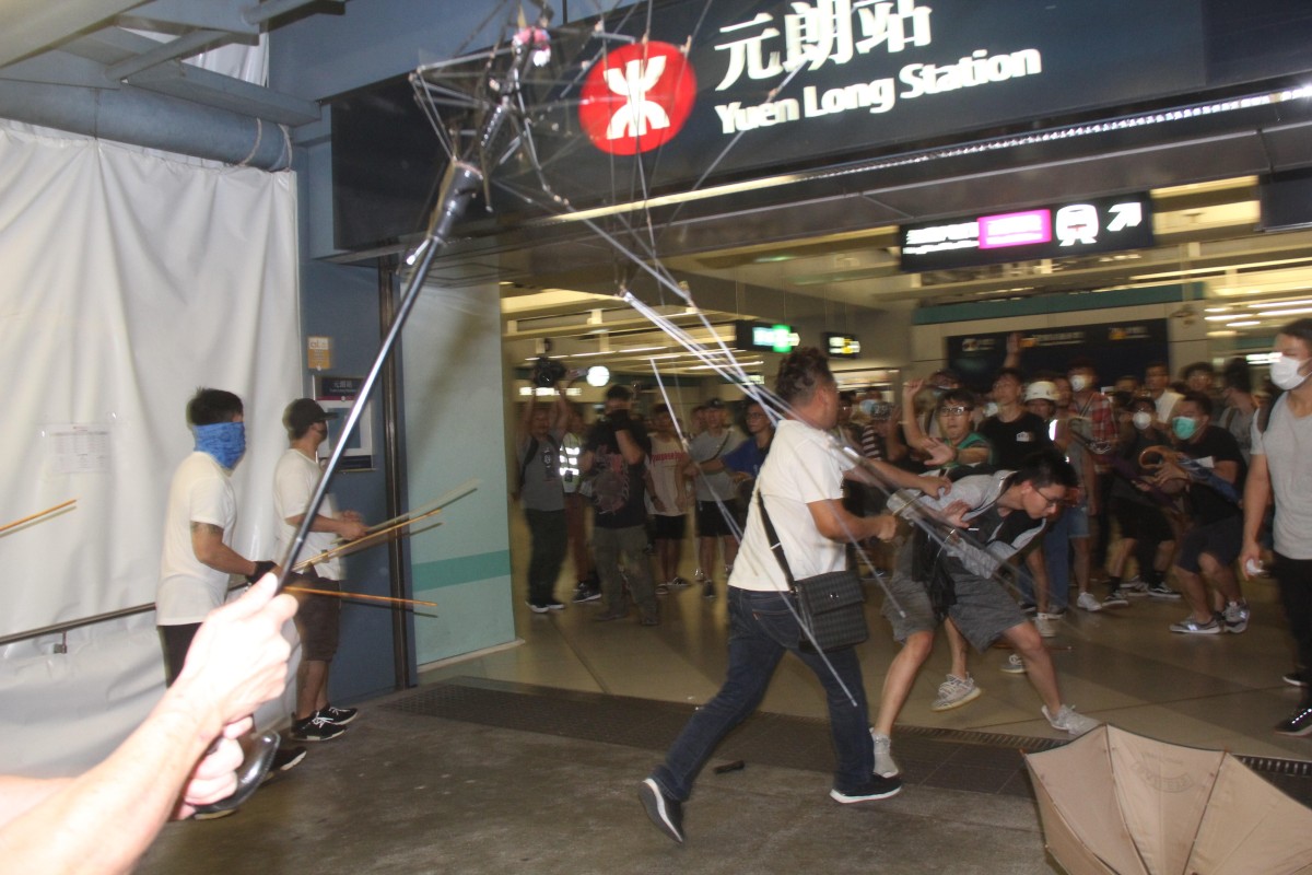 A mob of men in white T-shirts attack protesters and passengers at Yuen Long MTR station.