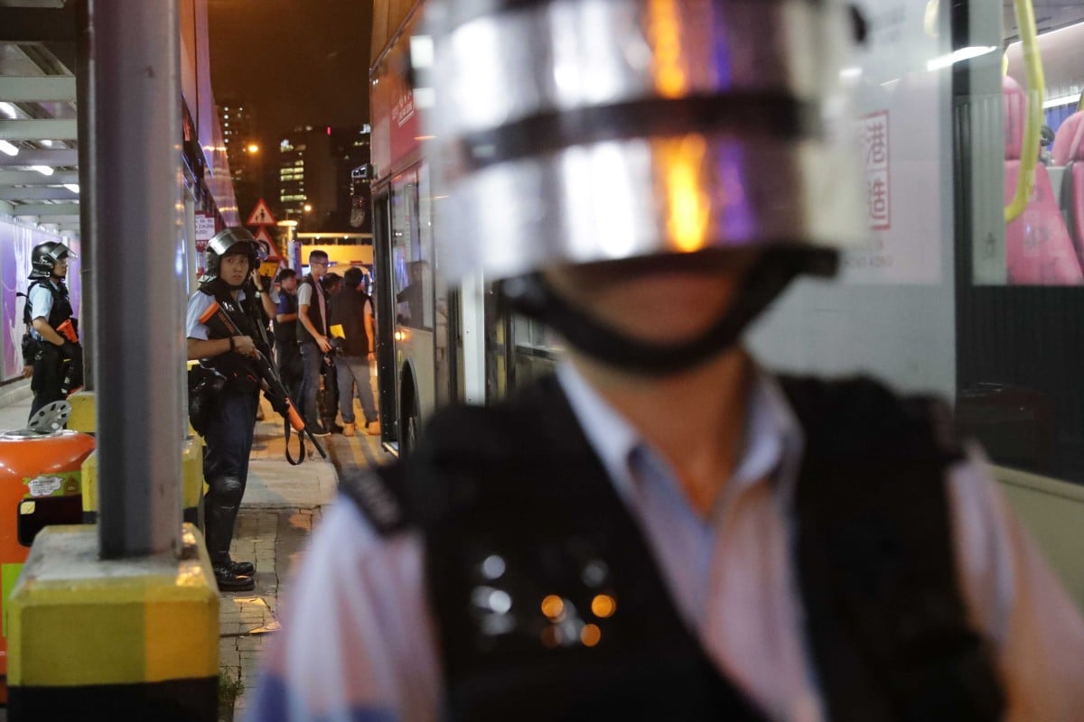 Police search for anti-government protesters on the bus in Kowloon Bay.