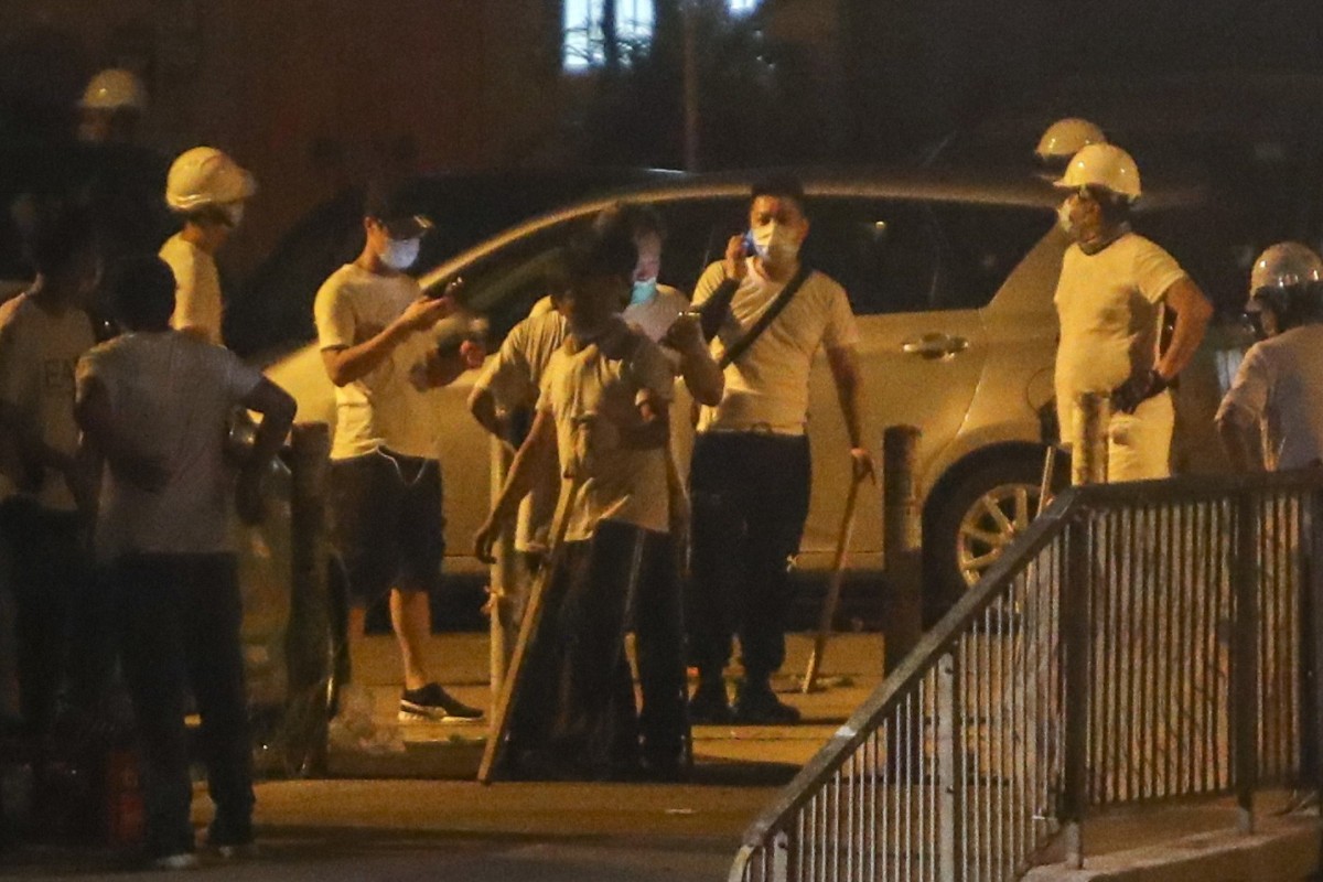 Men in white T-shirts attacked black-clad protesters and passengers.