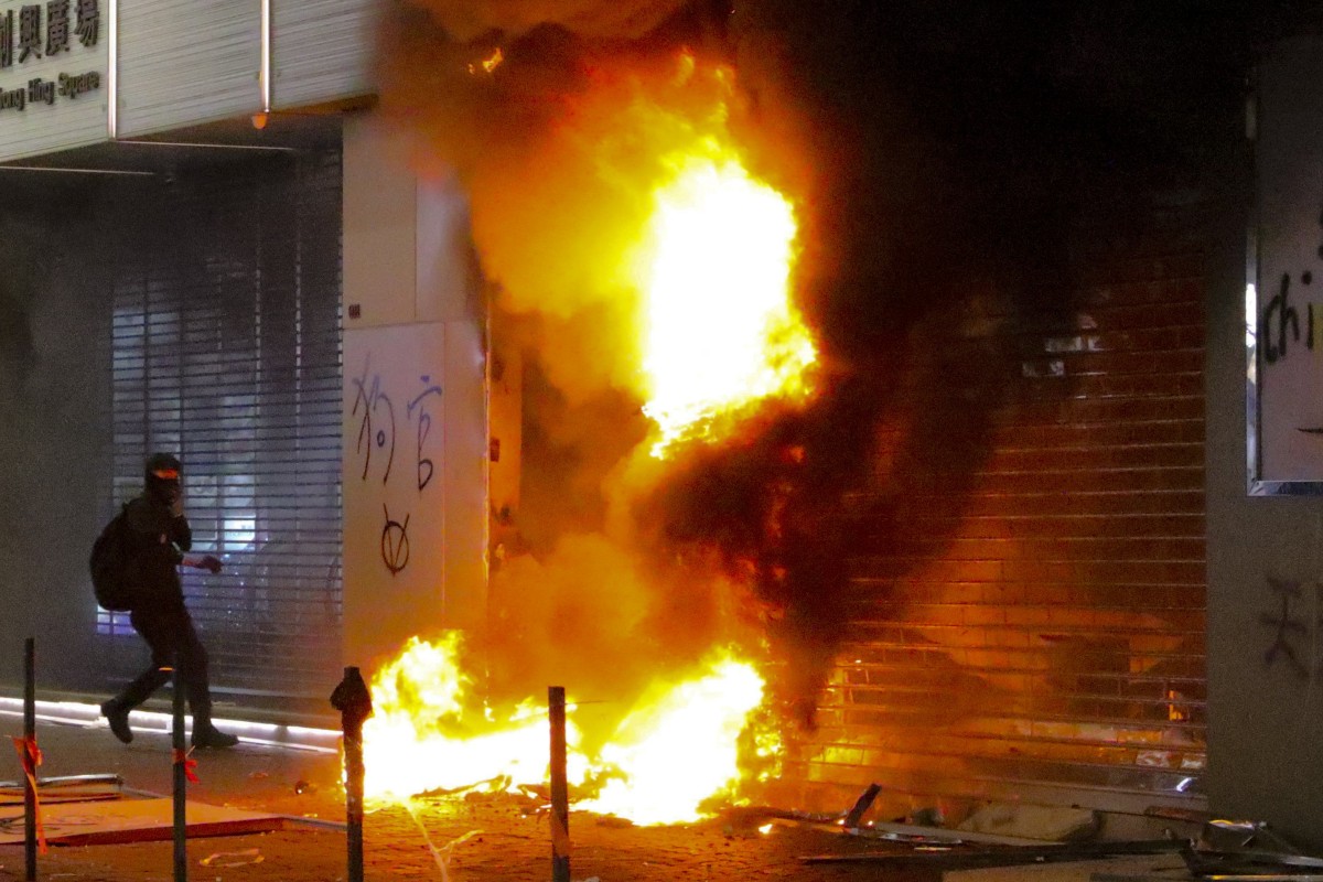 Masked anti-government protesters set stores on fire.