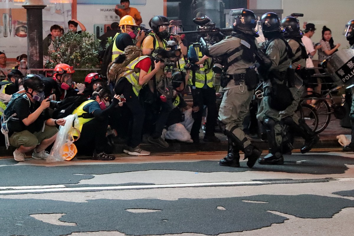 Riot police confront a group of media personnel in Mong Kok as citywide protests continued into the 21st straight weekend.