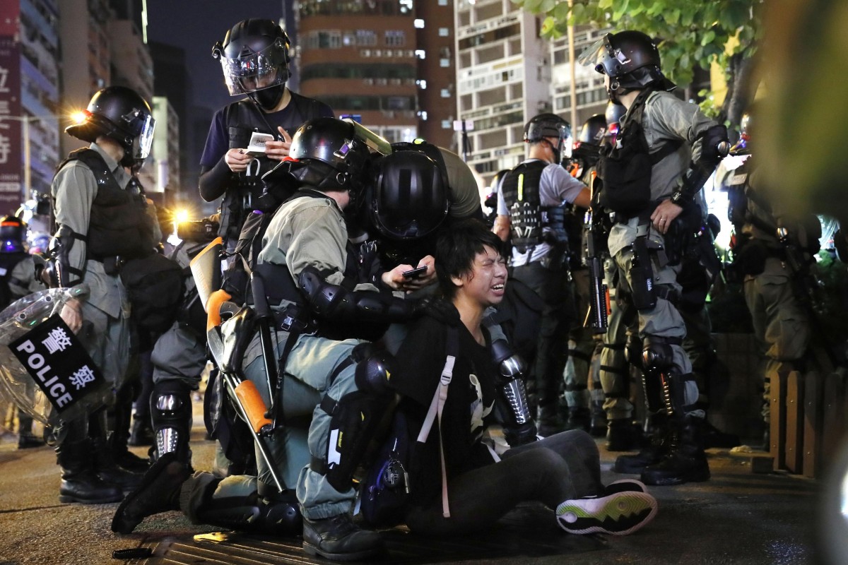 Police restrain a protester near a police station in the Mong Kok shopping district on Monday. Chinese commentators are criticising Apple Inc for making available an app that would allow users to avoid police actions in Hong Kong. Photo: Kyodo