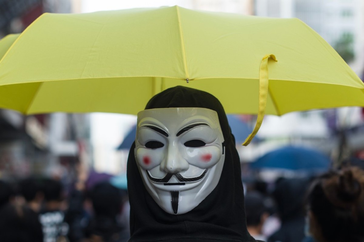 A protester wearing a Guy Fawkes mask taking part in a march.