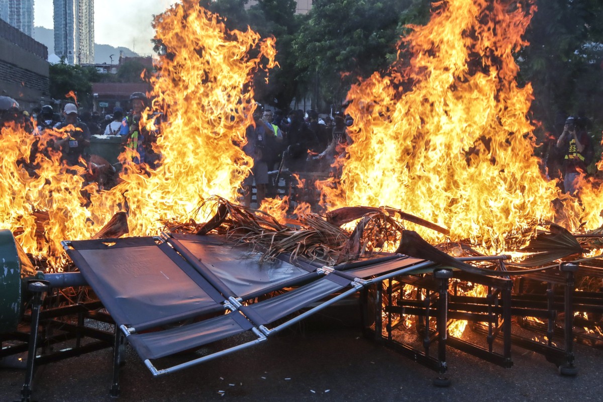 Protesters set fire to a roadblock after vandalising MTR facilities at New Town Plaza and Sha Tin stations.