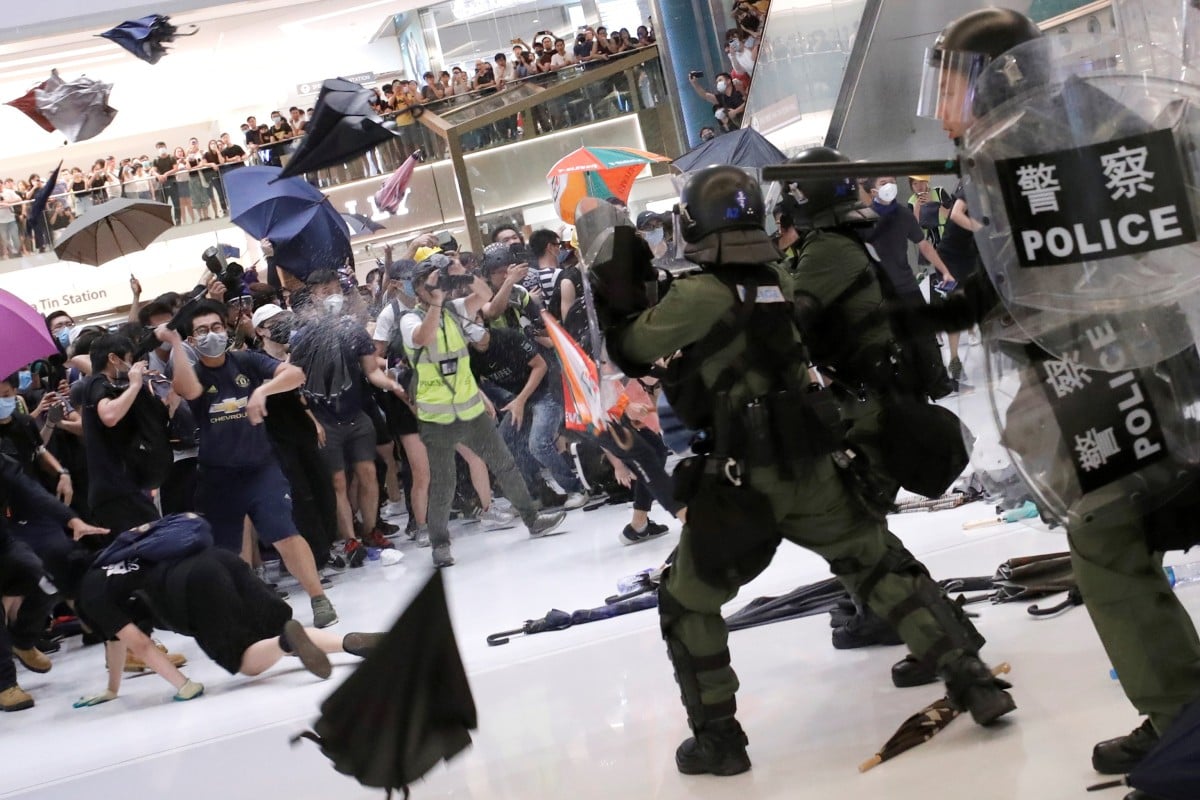 Riot police use pepper spray to disperse protesters in Hong Kong who returned fire with umbrellas and bottles.