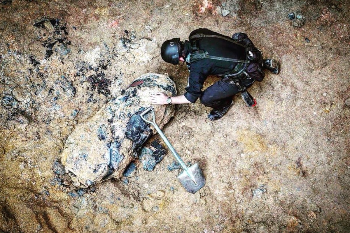 An officer from the Explosive Ordnance Disposal Bureau defusing a wartime bomb.