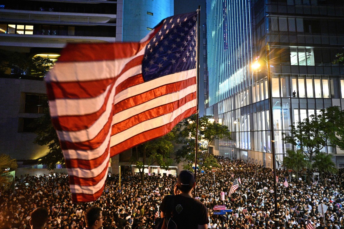 A man waves an American flag at a protest rally in Hong Kong on Monday as demonstrators called on US lawmakers to pass the Hong Kong Human Rights and Democracy Act of 2019.