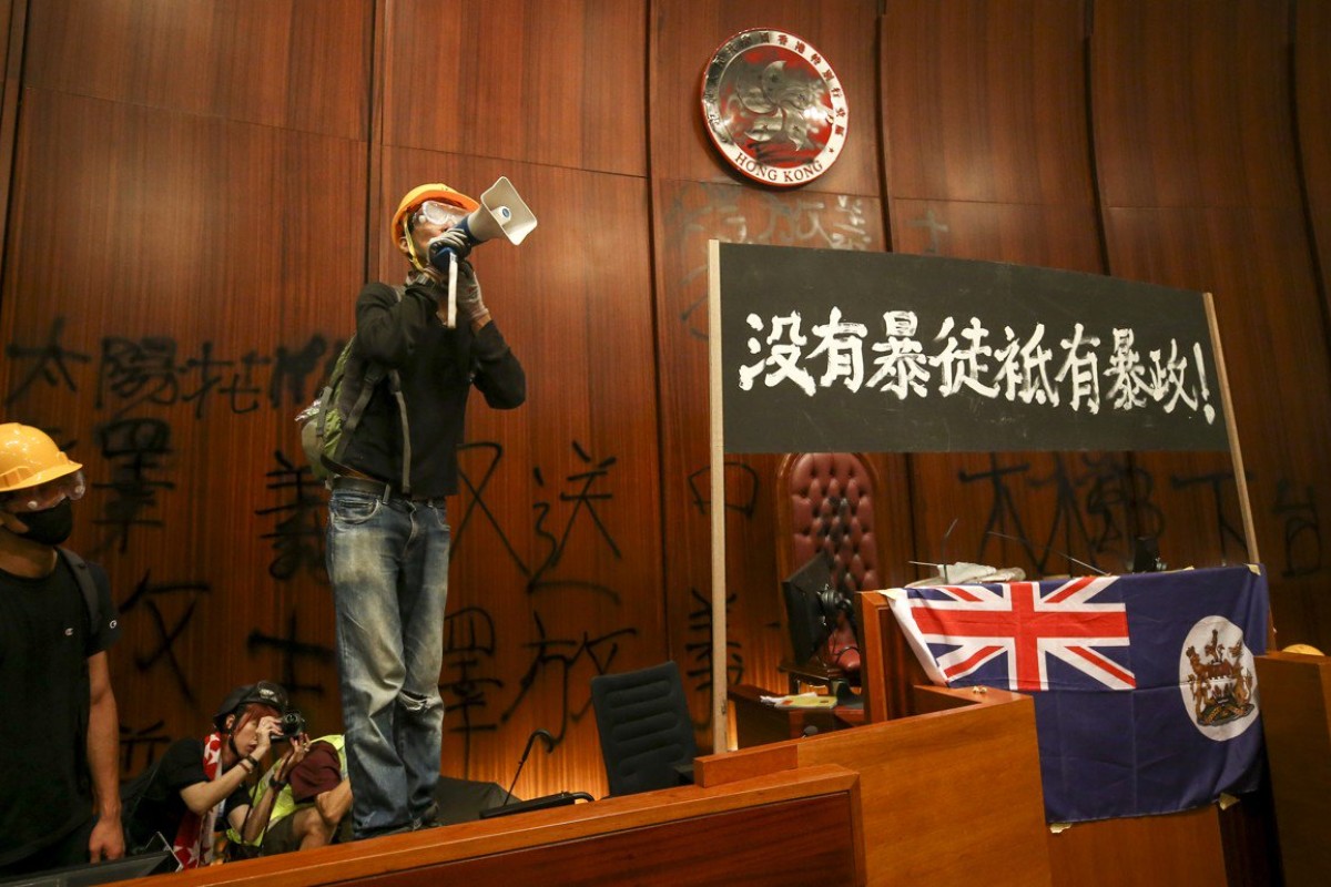 Protesters sprayed over the Bauhinia symbol and hung a colonial Hong Kong flag.