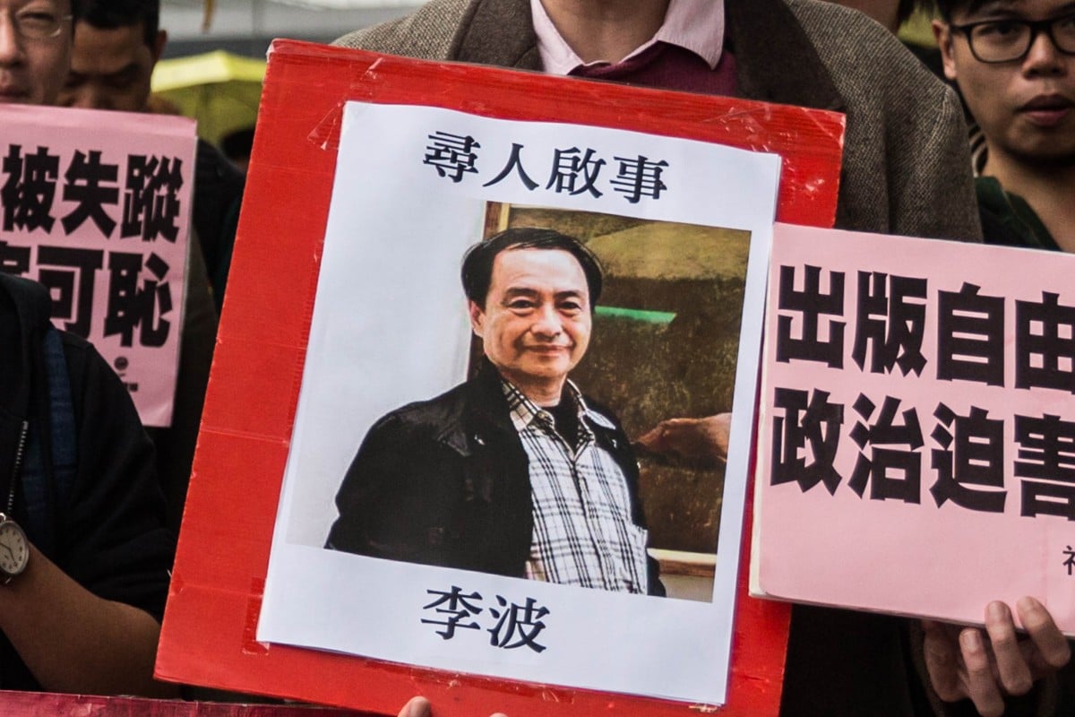 A protester holds up a missing person notice for Lee Bo,