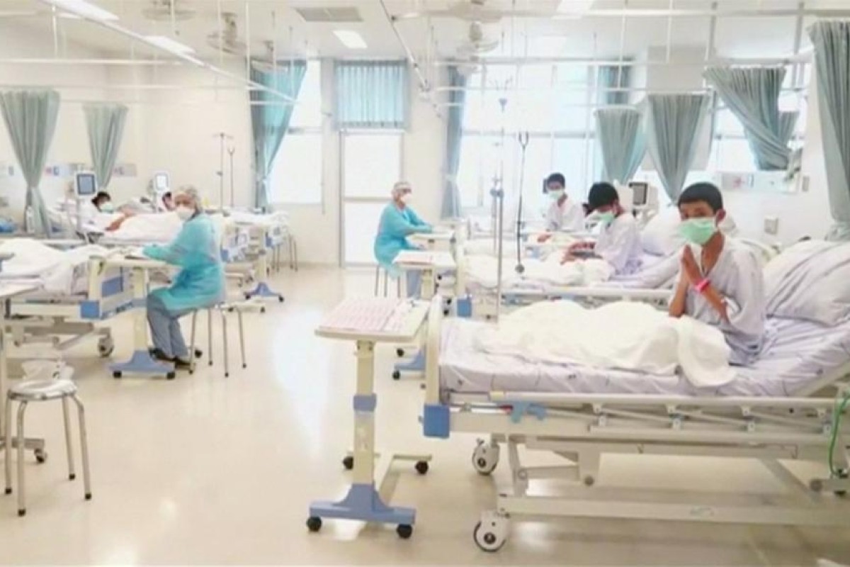 Boys rescued from the Thai cave wear masks and rest at a hospital in Chiang Rai.