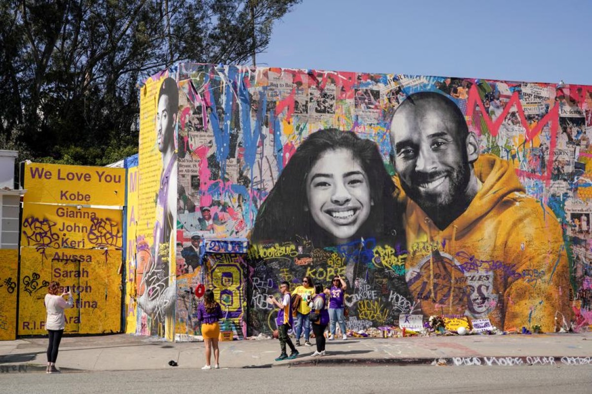Fans gather around a mural of late NBA great Kobe Bryant and his daughter Gianna Bryant during a public memorial for them and seven others killed in a helicopter crash, at the Staples Center in Los Angeles.