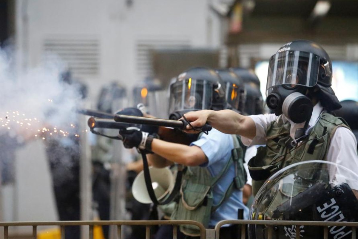 Police officers fire less than lethal ammunition on protesters during a demonstration against the proposed extradition bill in Hong Kong.