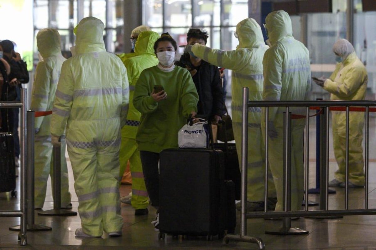 Passengers at a train station in Shanghai have their travel history checked.