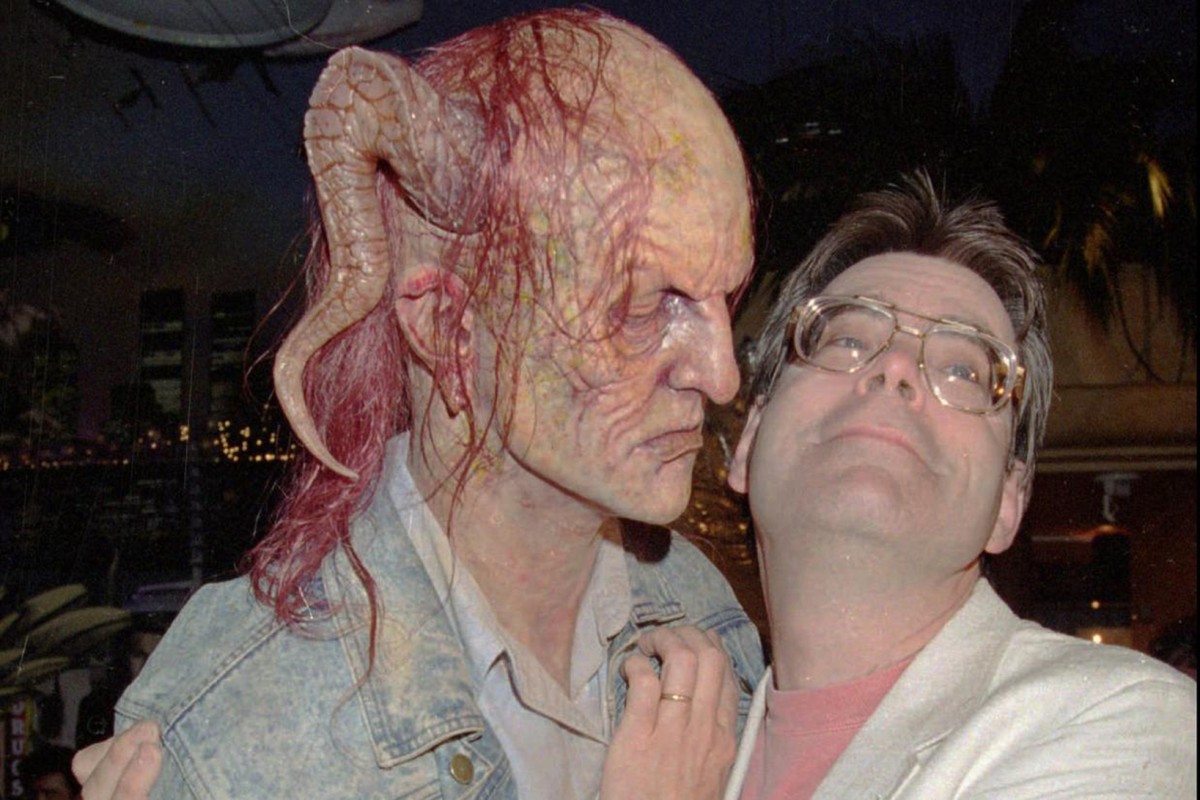 Stephen King with a mask of the character Randall Flagg from The Stand.