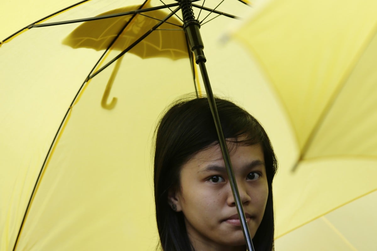 A protester holds a yellow umbrella as she joins a rally outside the Chinese Consulate at the financial district of Makati city east of Manila, Philippines.