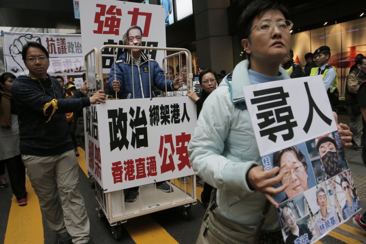Earlier this month, a protester wearing a mask of missing bookseller Lee Bo stands in a cage during a protest against the disappearances of booksellers in Hong Kong.