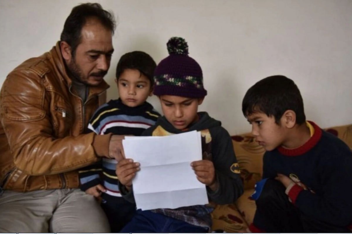 Zaher, 8, a Syrian refugee, reads a letter from Gunter Nitsch, a German World War II refugee.